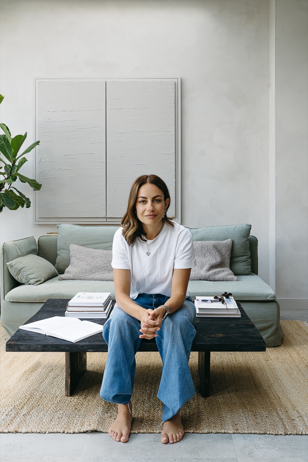 Julie Fedele sitting on a low table in jeans