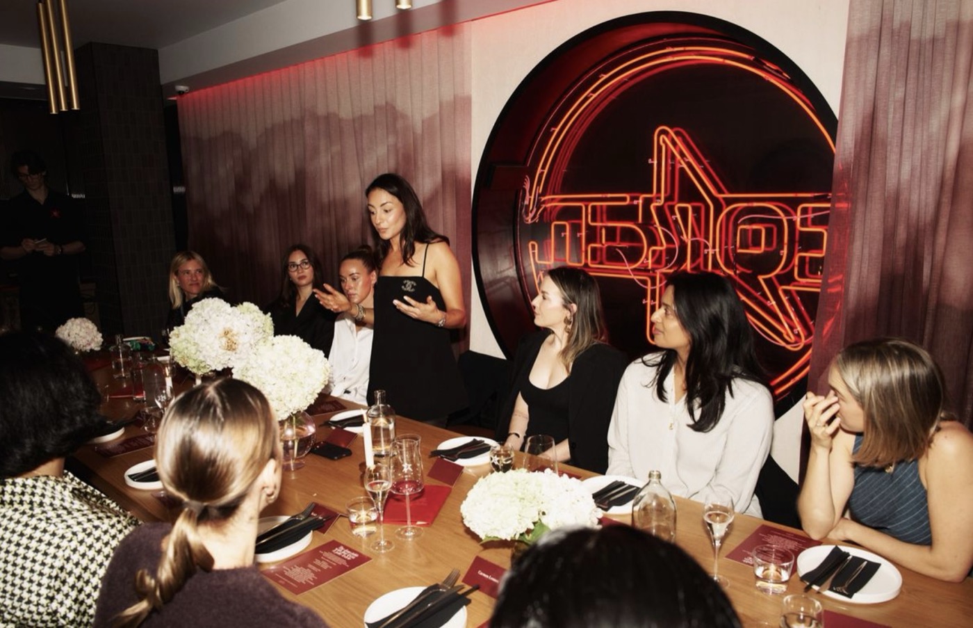Julie speaking to a room of women at a Polywork dinner